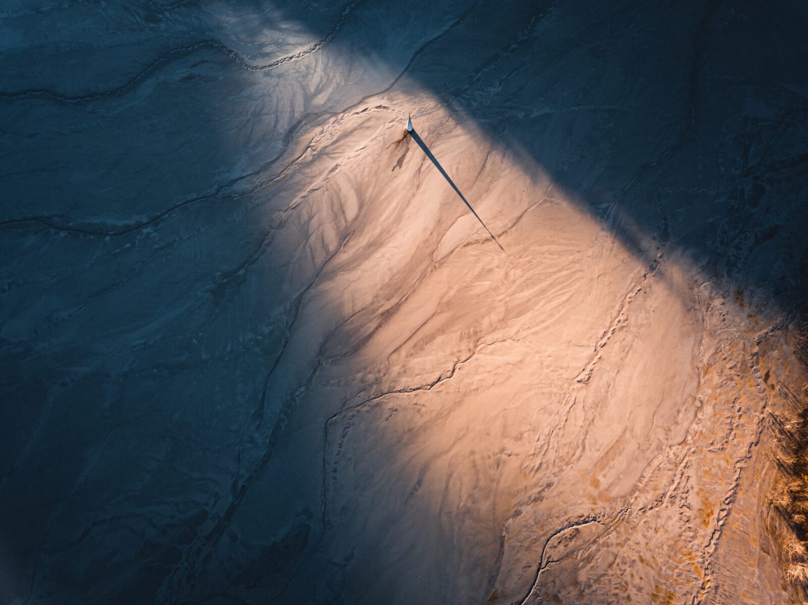 Abstract aerial view with contrasting colors and prominent shadow.