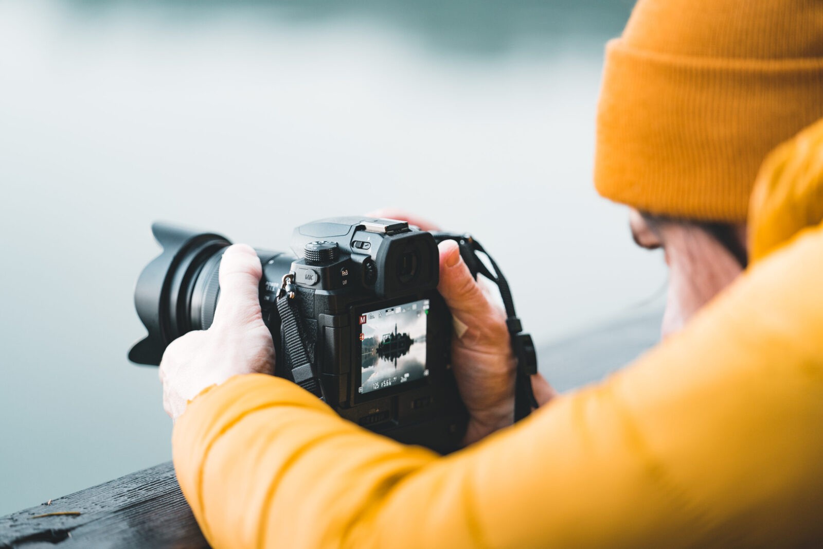 Male Photographer closeup, taking a photo of Lake Bled.