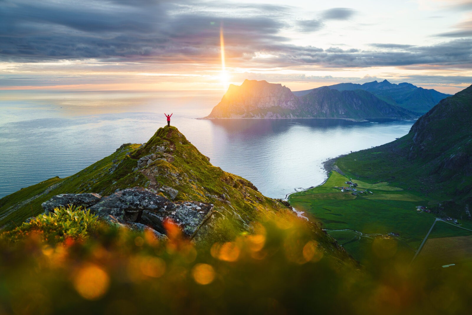 Lofoten Islands, Norway mountain peak sunset with person silhouette.