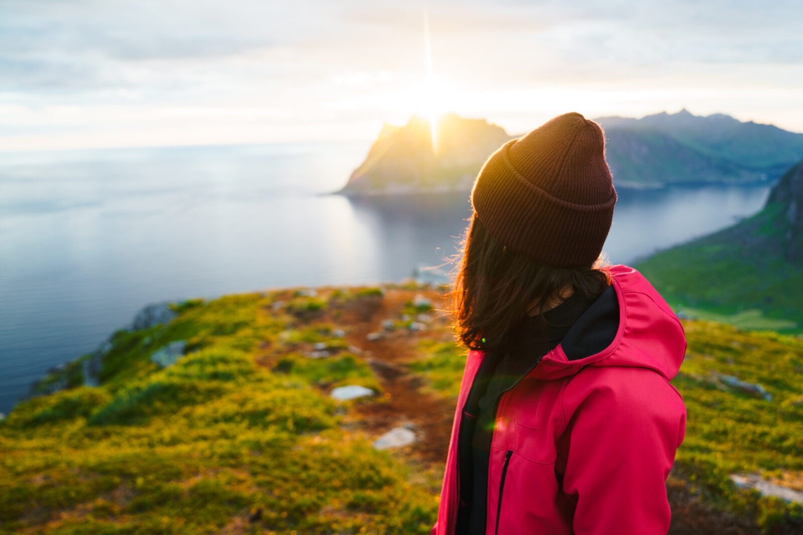 Woman hiking on top of the mountain, enjoying the sunset.